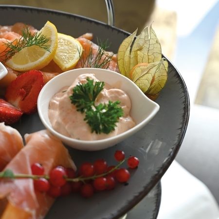 Platte mit Räucherlachs, Saucen, Zitrone und frischen Beeren