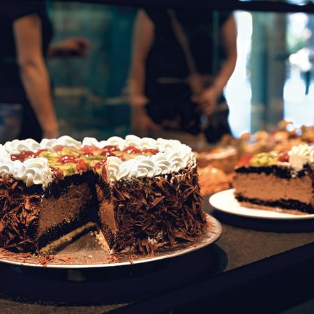 Zwei Schokoladenkuchen mit Früchten und Sahne in der Auslage