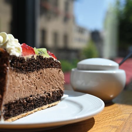 Ein Stück Schokoladenkuchen mit Schlagsahne und Fruchtbelag